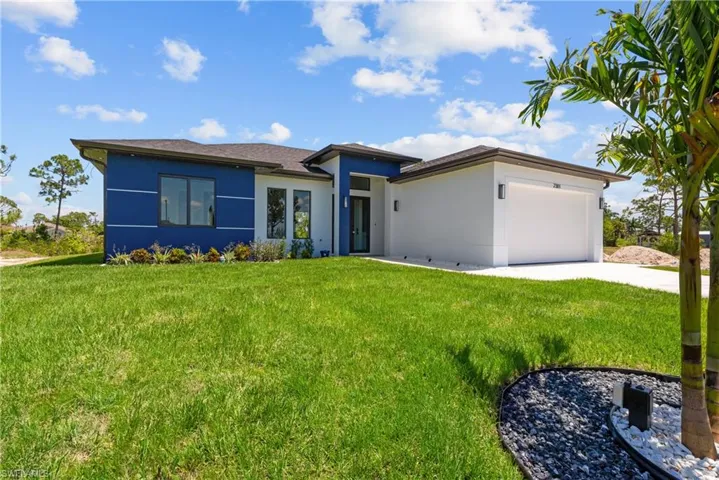 Prairie-style house featuring an attached garage, driveway, stucco siding, and a front yard