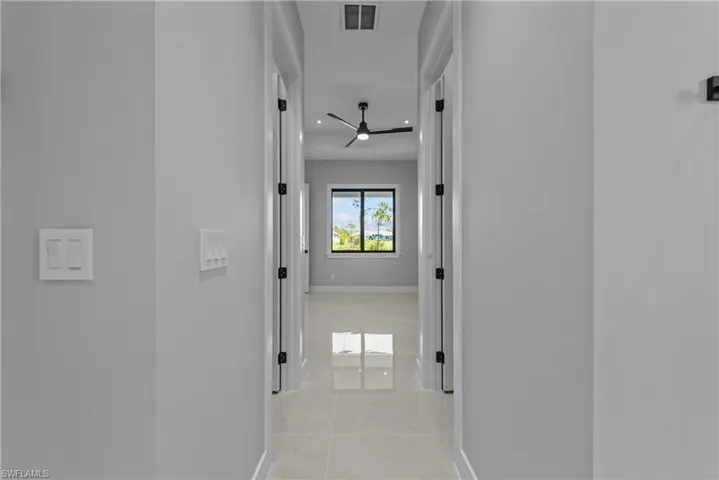 Hallway featuring baseboards and light marble finish floors