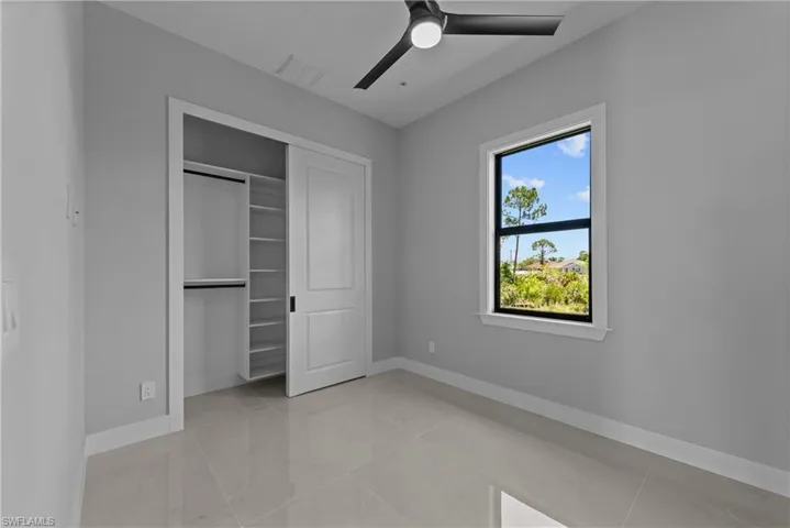 Unfurnished bedroom featuring baseboards, a closet, and ceiling fan
