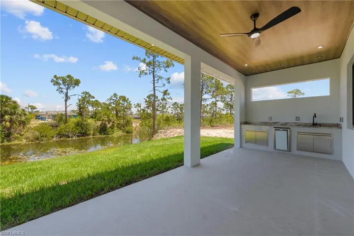 View of patio / terrace with a water view, area for grilling, ceiling fan, and a sink
