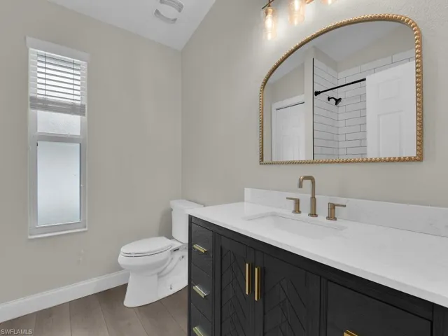 Guest bathroom featuring new dark expresso vanity with quartz top, gold fixtures and updated shower.