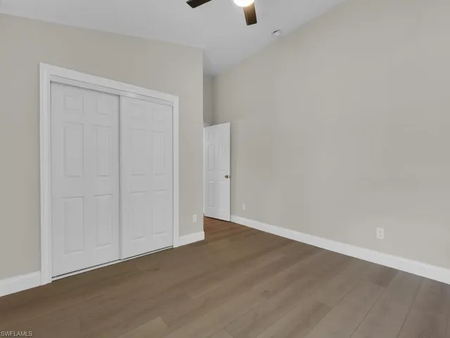 Unfurnished bedroom with wood finished floors, a ceiling fan, and a closet