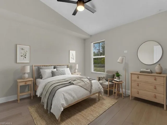 Bedroom featuring light wood-style flooring, vaulted ceiling, and a ceiling fan