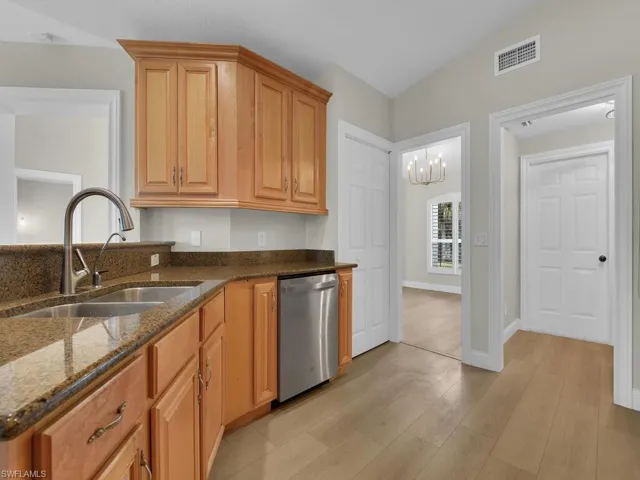 Kitchen features double sink, stainless-steel appliances and light wood finished floors. Easy passway to dining area from kitchen