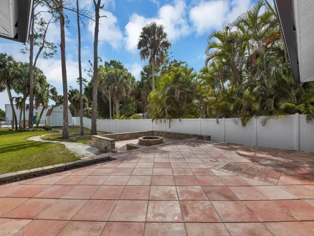 Fenced backyard with an outdoor fire pit and a patio area