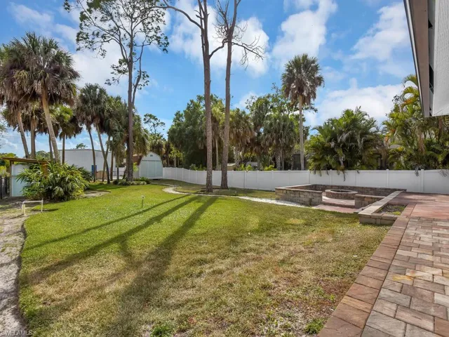 Fenced backyard featuring a patio area and fire pit