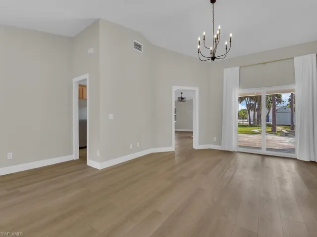 Unfurnished dining area featuring updated lighting, light wood-style flooring, and lofted ceiling