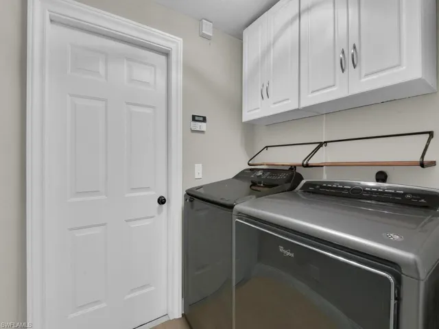 Inside laundry room just off the garage with extra cabinet space. Laundry sink in garage.