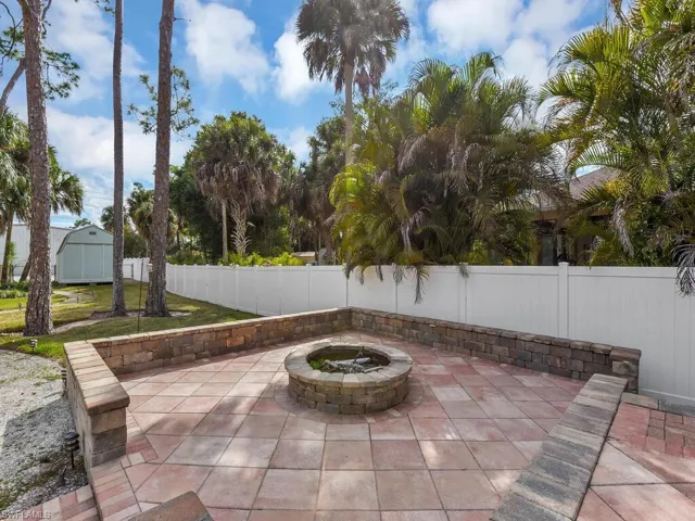 Fenced backyard featuring an outdoor fire pit & patio area.