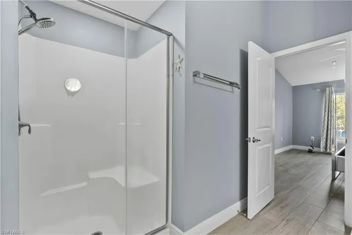 Bathroom with a shower stall and wood finish floors