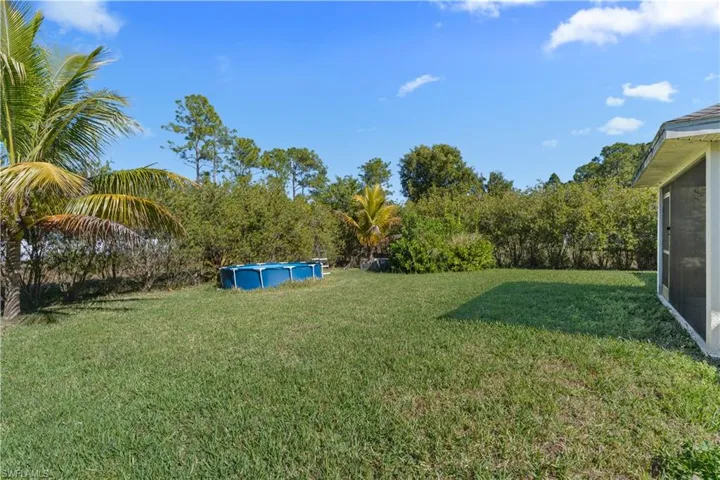 View of grassy yard with an outdoor pool