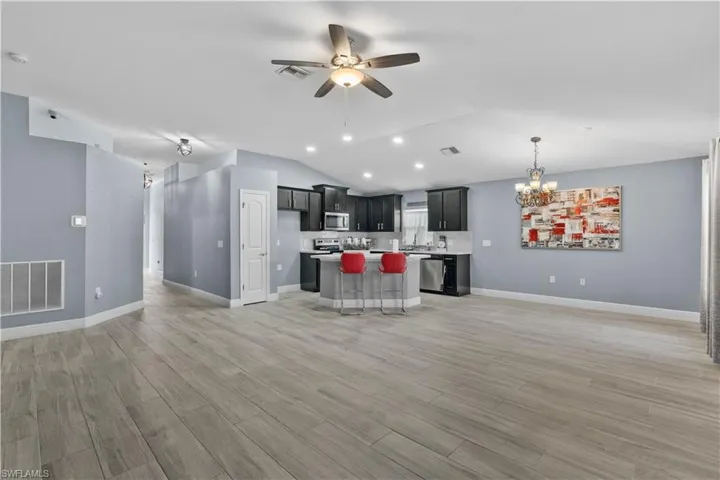 Kitchen featuring open floor plan, a center island, a chandelier, light countertops, and a breakfast bar area