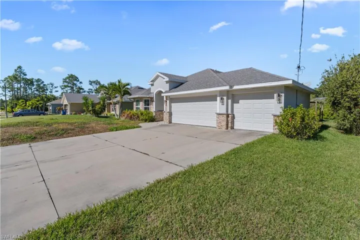 View of home's exterior with a lawn, an attached garage, concrete driveway, and stucco siding