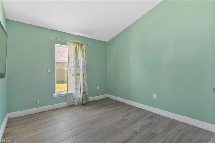 Spare room featuring baseboards and wood tiled floors