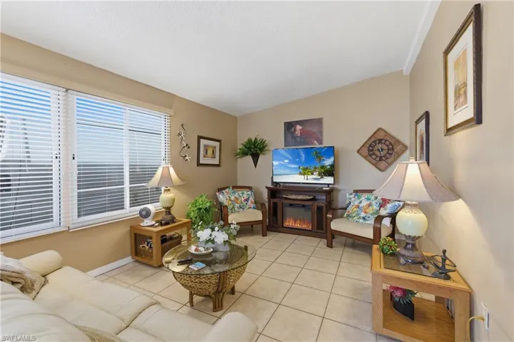 Living room featuring tile patterned floors and a glass covered fireplace