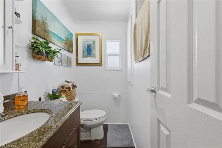 Half bathroom featuring vanity and crown molding