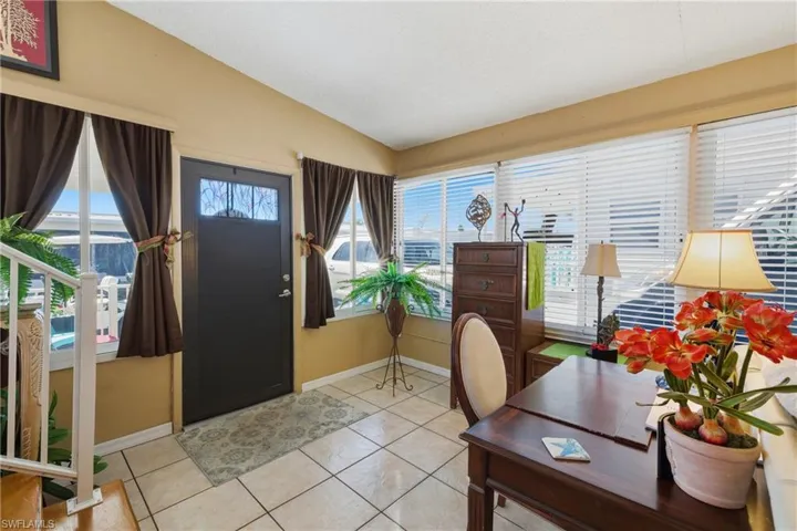 Office area with light tile patterned flooring and vaulted ceiling