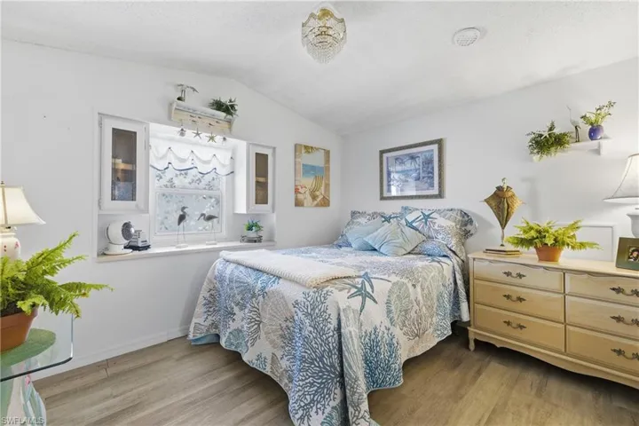 Bedroom with lofted ceiling and light wood-type flooring