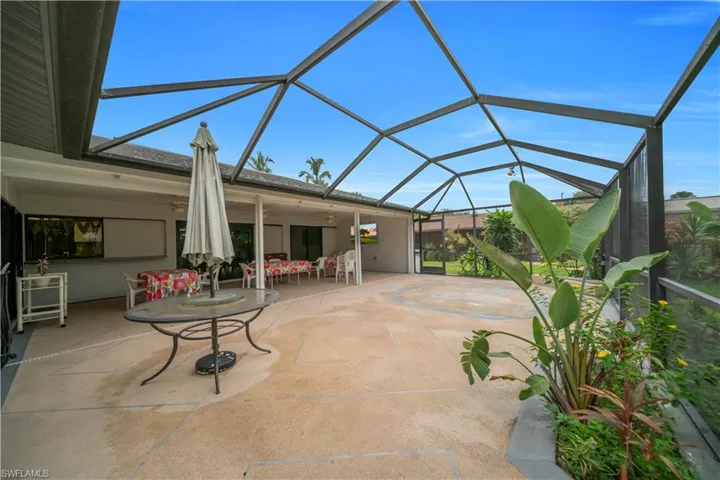 View of patio / terrace featuring glass enclosure, a sunroom, a ceiling fan, and outdoor dining space
