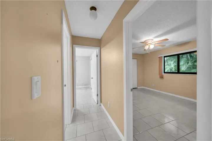 Corridor featuring light tile patterned floors and a textured ceiling