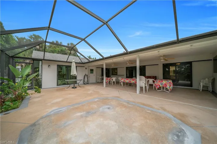 Back of house with ceiling fan, a lanai, a sunroom, and stucco siding