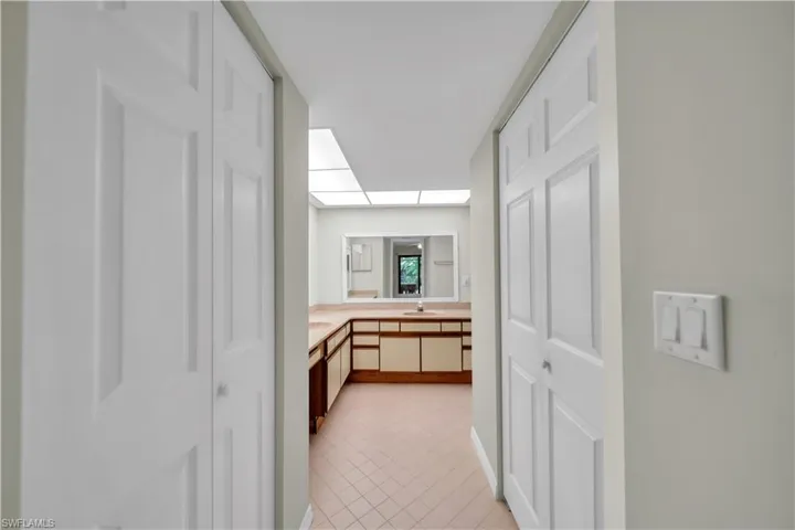 Hall with light tile patterned flooring and a sink