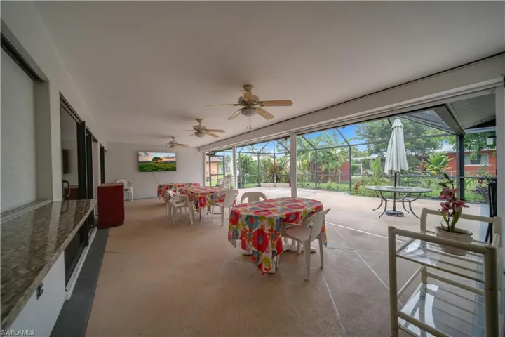 Sunroom featuring outdoor dining space, ceiling fan, and a patio
