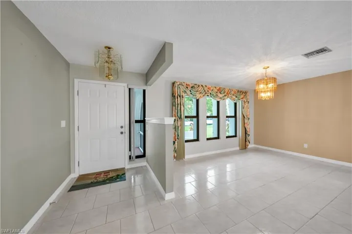 Foyer with a chandelier, light tile patterned floors, and a textured ceiling