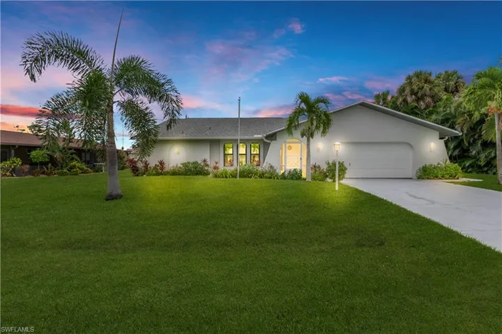 Ranch-style home with stucco siding, a yard, concrete driveway, and an attached garage