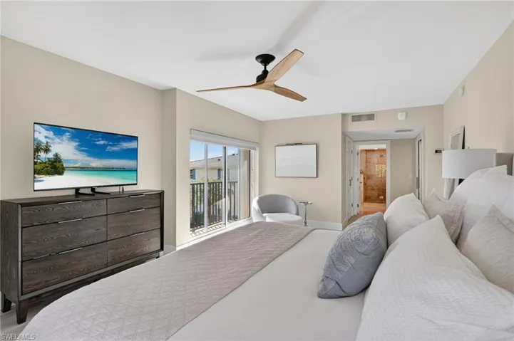 Bedroom featuring connected bathroom, ceiling fan, and access to exterior