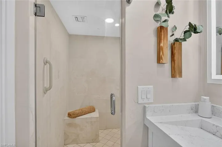 Full bathroom with vanity and a marble finish shower
