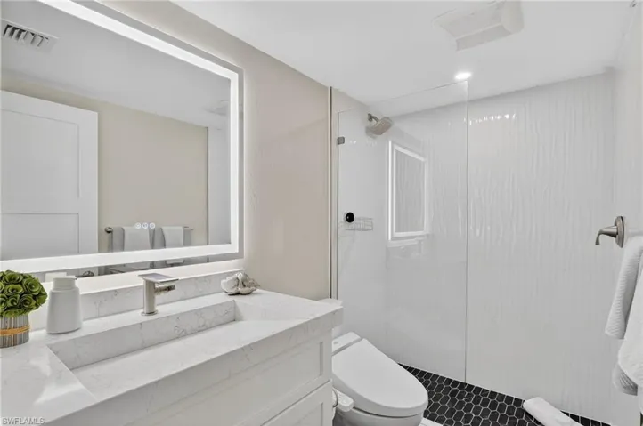 Bathroom featuring walk in shower and vanity