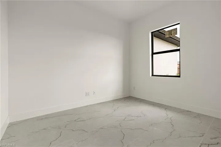 Spare room with light marble finish flooring and baseboards