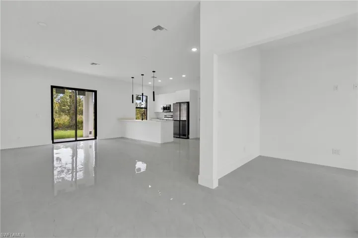 Unfurnished living room with recessed lighting and baseboards