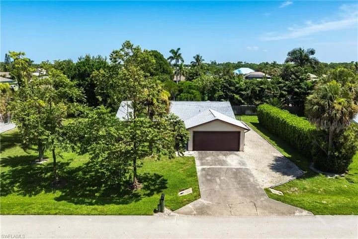 View of front facade with concrete driveway, a front yard, and a garage