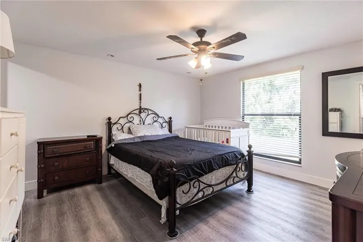 Primary bedroom with wood finished floors and ceiling fan