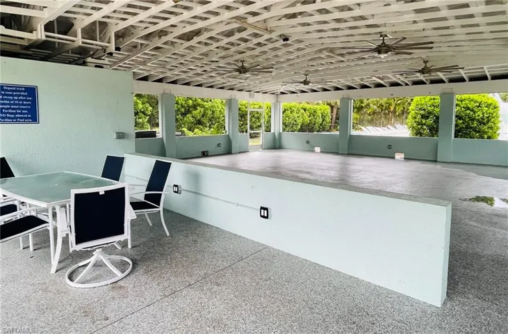 View of clubhouse with outdoor dining space and ceiling fan