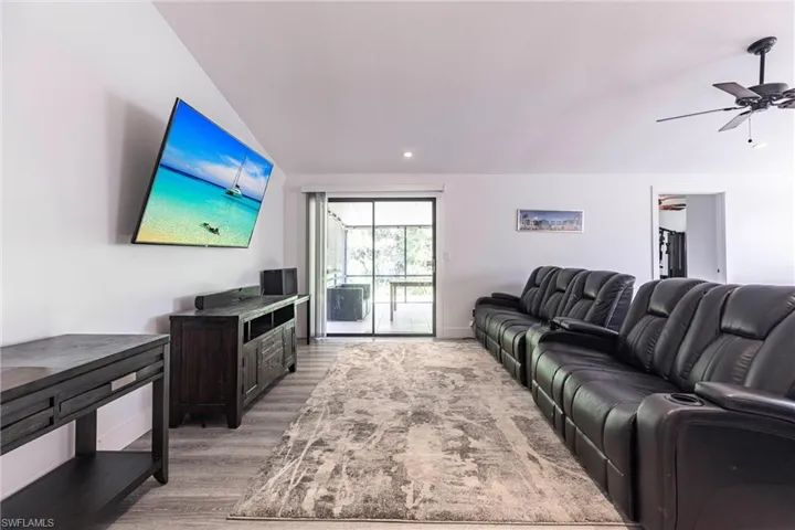 Living area featuring a ceiling fan, vaulted ceiling, light wood-style floors, and recessed lighting