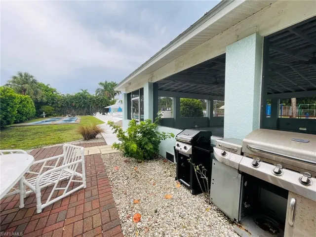 View of clubhouse terrace featuring an outdoor pool and grilling area