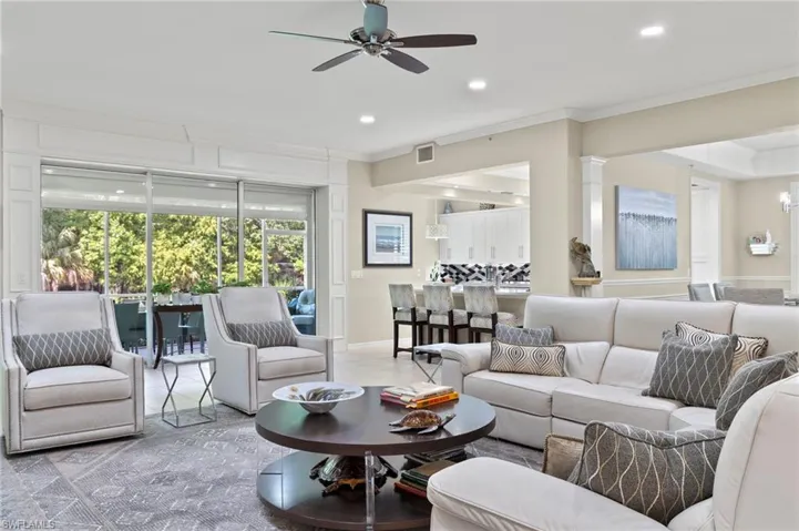 Living room with ornamental molding and ceiling fan