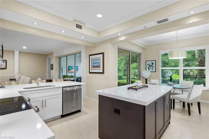 Kitchen featuring white cabinetry, decorative light fixtures, sink, dishwasher, and light tile patterned floors