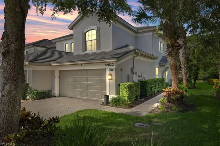 View of front of house featuring a garage and a lawn