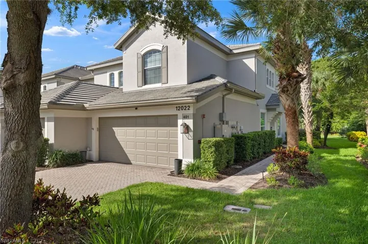 View of front of home with a garage, central AC, and a front lawn