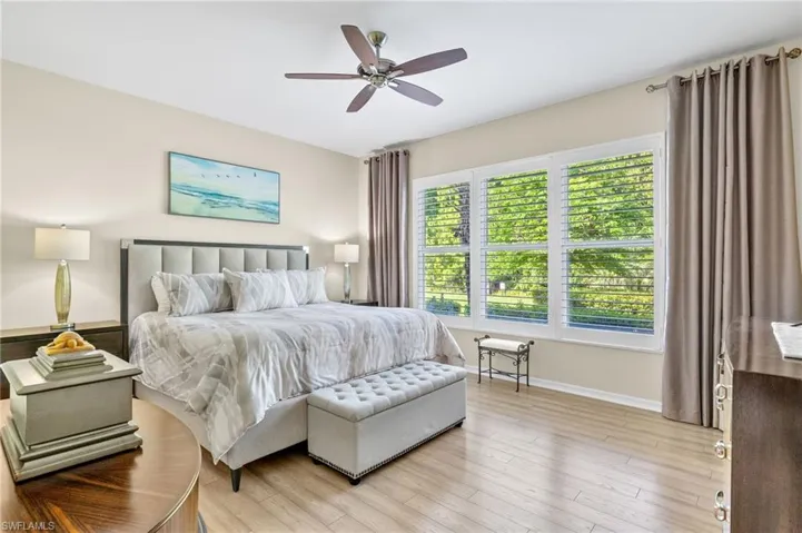 Bedroom featuring multiple windows, light wood-type flooring, and ceiling fan