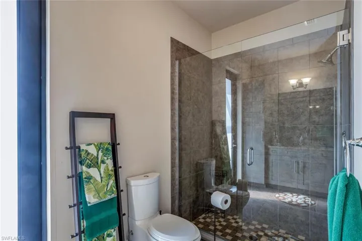 Bathroom with a shower stall and toilet