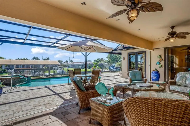 View of patio featuring a ceiling fan, french doors, and a pool with connected hot tub