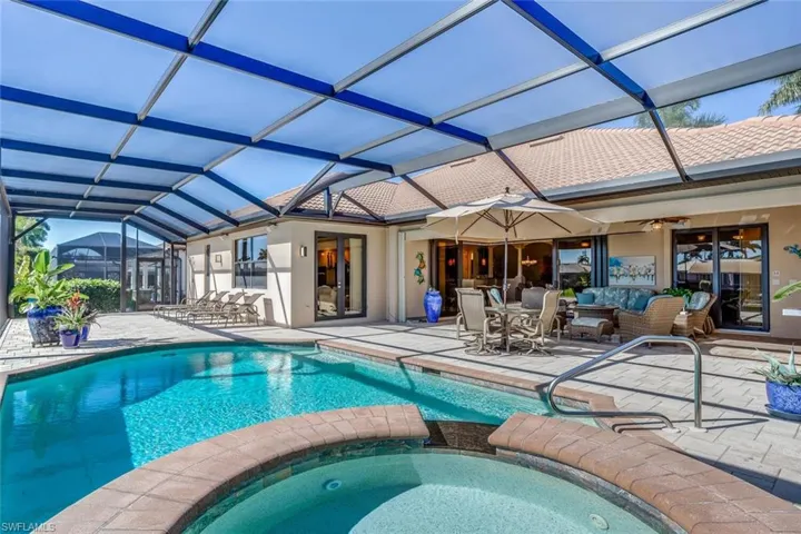 View of swimming pool with a sunroom, a patio, glass enclosure, and a pool with connected hot tub