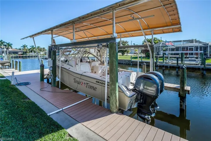 Dock area featuring boat lift and a water view