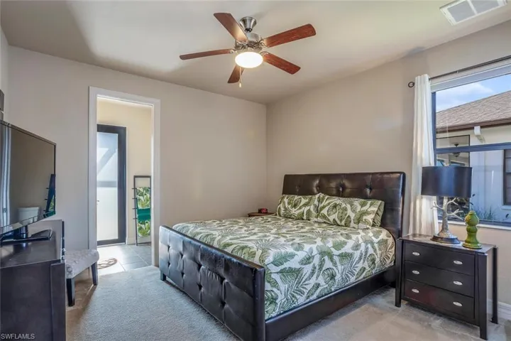 Carpeted bedroom featuring access to exterior and ceiling fan