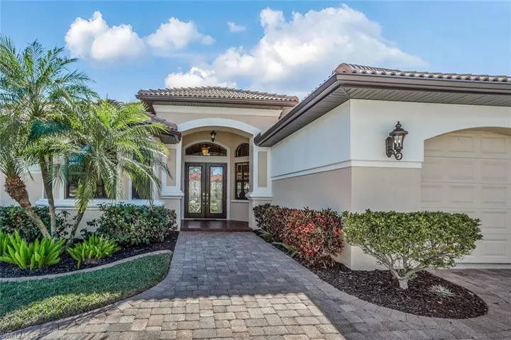 Entrance to property with french doors, stucco siding, an attached garage, and a tiled roof